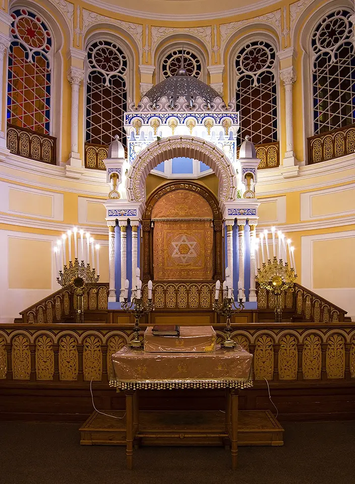 A large wooden chair in the middle of an altar.